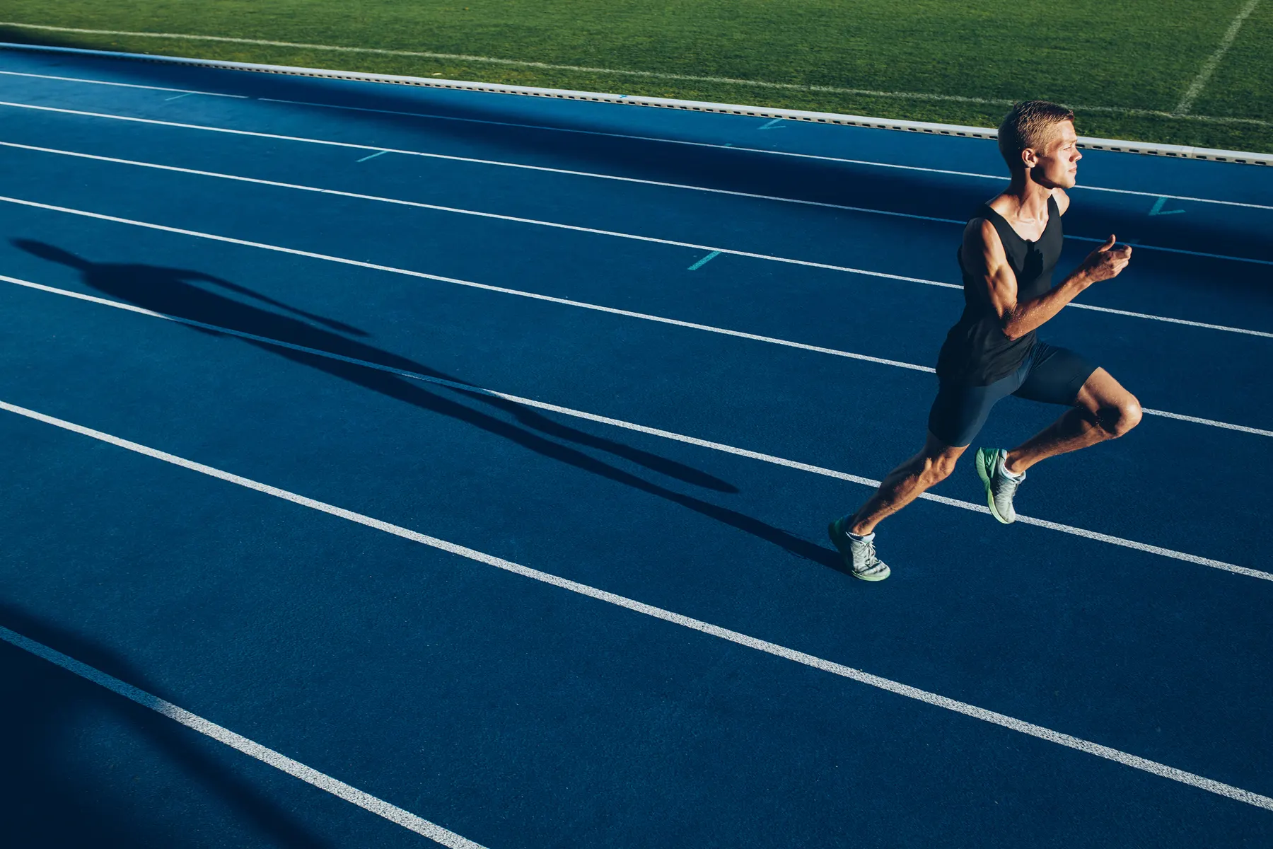 Athlete sprinting on a blue running track